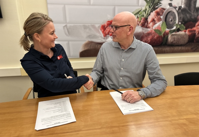 Forhandlingssekretær i Fødevareforbundet NNF Mette Bisgaard og direktør i DSM Leif Wilson giver hinanden hånden på en ny treårig overenskomst