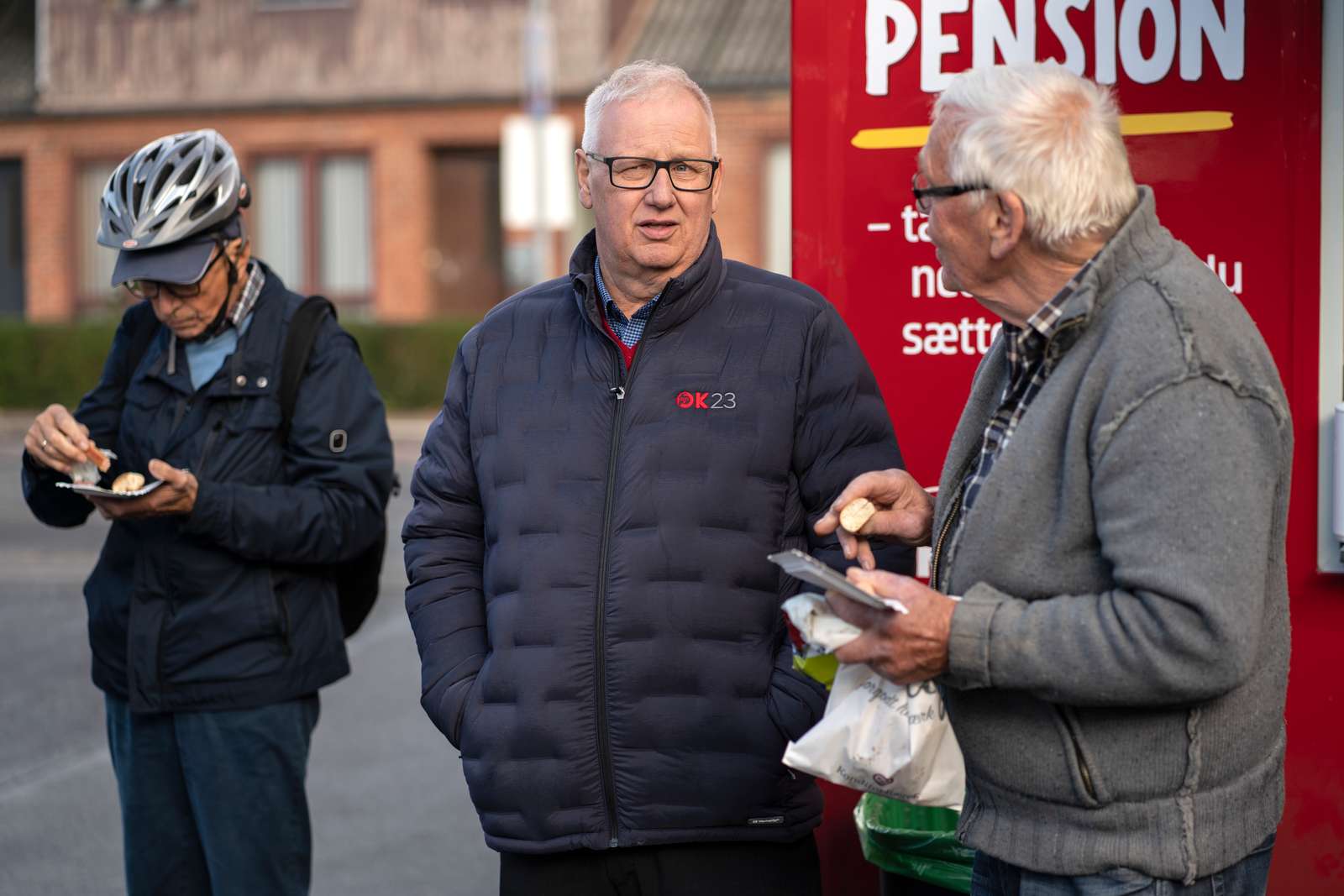 Ole Wehlast taler med handlende fra Grenå, der har fået en pølse og et stykke kage med.